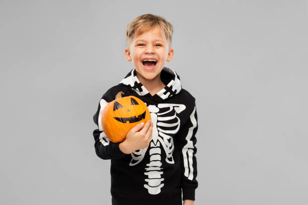 istock happy boy in halloween costume with jack-o-lantern 1392310970