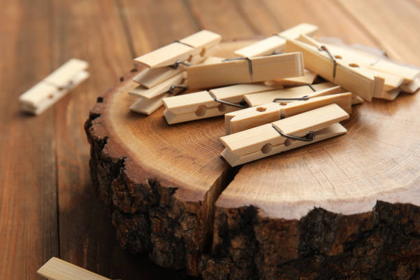 istock Many wooden clothespins and decorative stump on table, closeup 1392311435