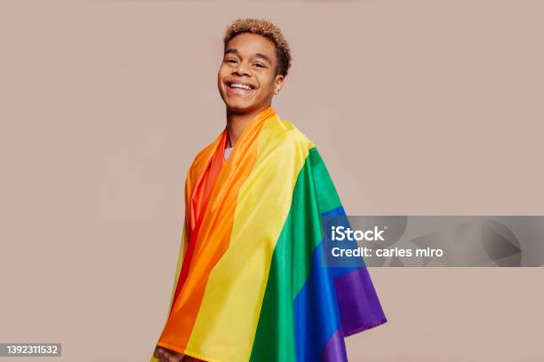 Cheerful Latin American Young Man With A Rainbow Flag Stock Photo - Download Image Now
