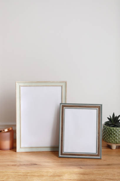 istock Empty photo frames and succulent on wooden table indoors 1392312865
