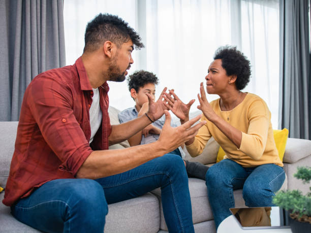 istock Parents arguing while the son is sitting between them at home. 1392314225