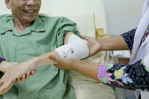 An Asian senior man is receiving treatment in hospital.