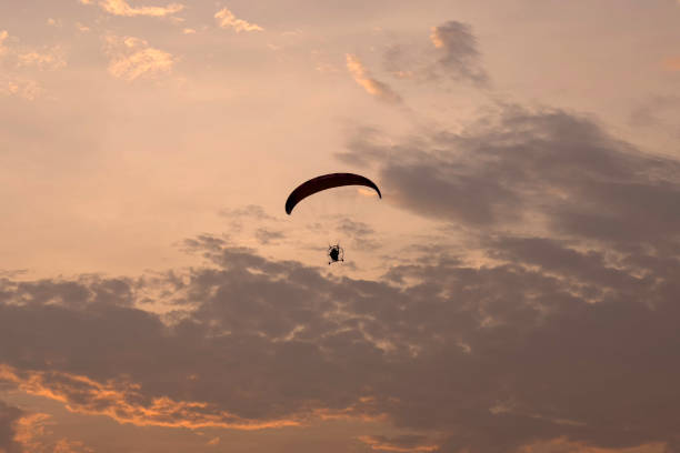 istock Motor paragliding over the sea at sunset 1392318950