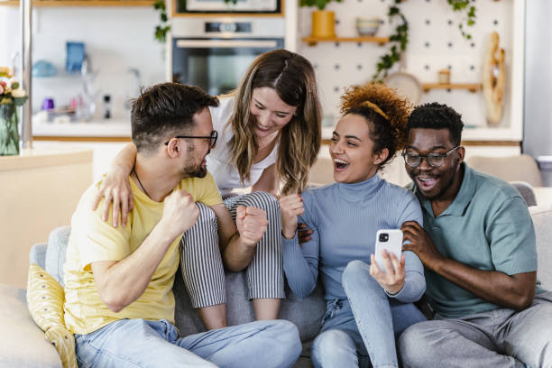 istock Multiethnic group of friends using mobile phone at home 1392319068