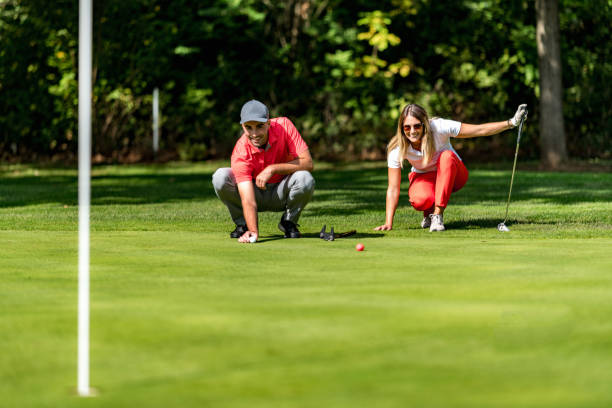 istock Young couple on a golf course, reading green 1392319214