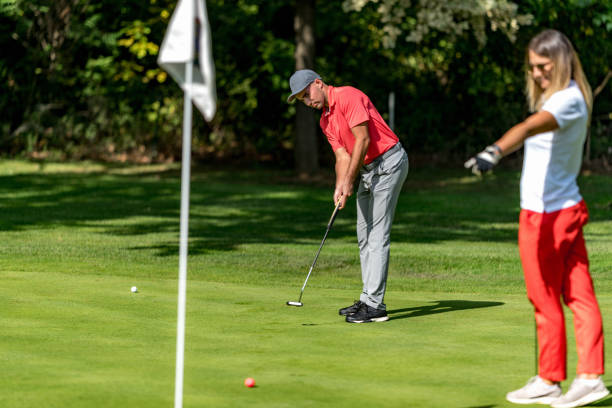 istock Young couple playing golf on a golf course, woman pointing to the golf hole 1392320149