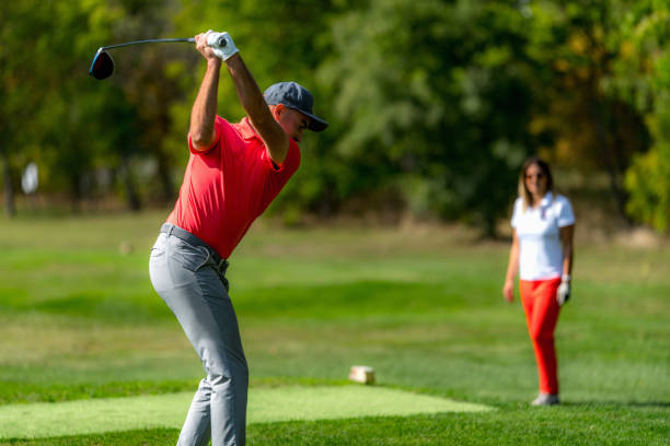 istock Young couple on a golfing vacation, man teeing off 1392320638