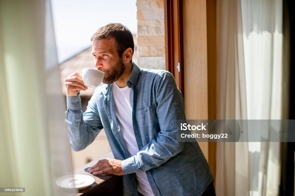 Young man with cup of hot tea at winter window Handsome young man with cup of hot tea at the winter window Men Stock Photo Young man with cup of hot tea at winter window Handsome young man with cup of hot tea at the winter window Men Stock Photo