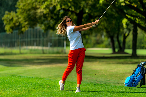 Woman playing golf. Young female golfer on the tee box