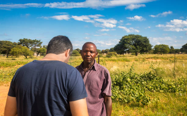 African and young Caucasian man talking in the village