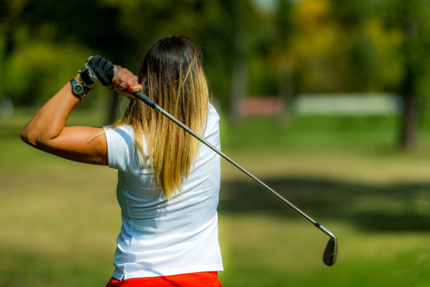 istock Woman playing golf, swing, rear view 1392323964