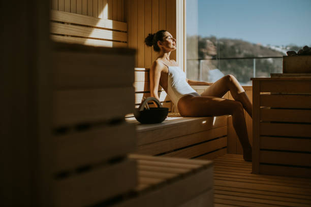 młoda kobieta relaksująca się w saunie - łaźnia zdjęcia i obrazy z banku zdjęć