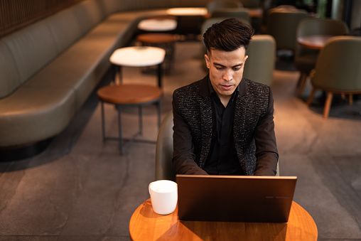 Young businessman using laptop computer in coffee shop