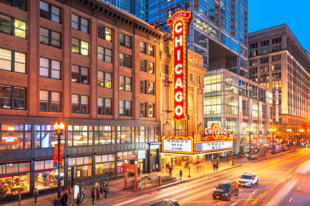 Chicago, Illinois, USA - May 10, 2018: Traffic and pedestrians pass the landmark Chicago Theatre on State Street at twilight. The historic theater dates from 1921.