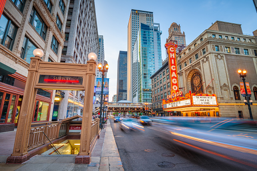 Chicago, Illinois, USA - May 10, 2018: Traffic and pedestrians pass the landmark Chicago Theatre on State Street at twilight. The historic theater dates from 1921.