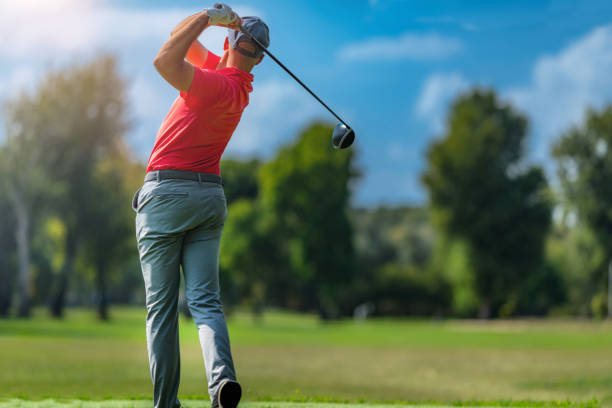 istock Pro golfer in a golf swing, using a driver golf club, rear view 1392325122