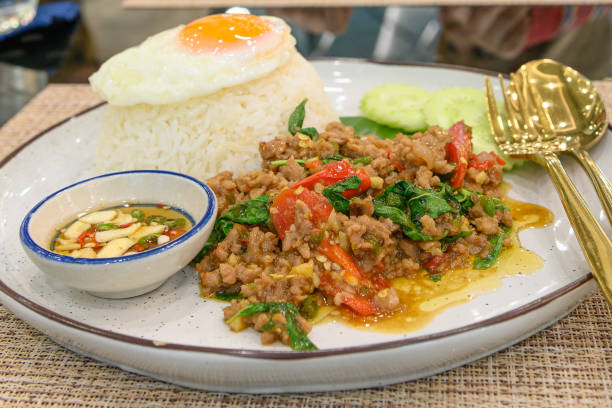 istock Stir fried Thai basil with minced pork and a fried egg on white plate 1392325170