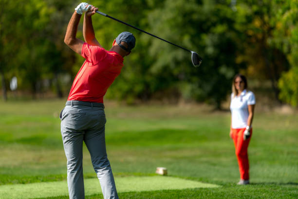 istock Young couple on a golfing vacation, man teeing off 1392325296