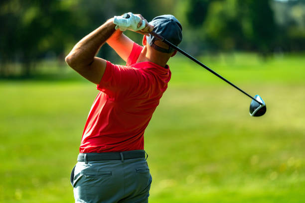 istock Professional golfer in a swing using a driver golf club, rear view 1392325377