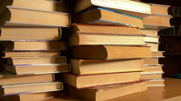 istock Books rotating on desk in library, archives in dark room 1392326427