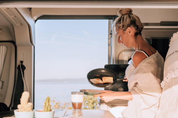 istock Woman prepares breakfast in a van, sea view 1392326541
