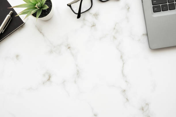 istock White marble office desk table with laptop computer and office supplies. Top view with copy space, flat lay. 1392327771