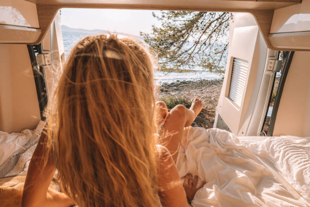 istock Woman in her van looking at ocean 1392328241