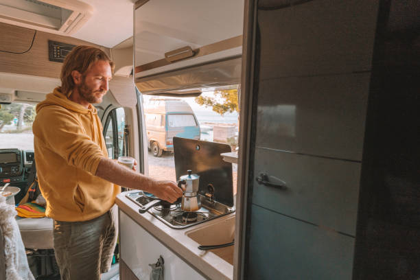 istock Man making coffee in his van, sea view 1392328404