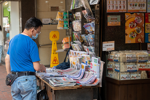 Torino, Italy; October 7, 2019: a man with glasses looks at magazines at a newsstand in piazza castello in turin, Italy.