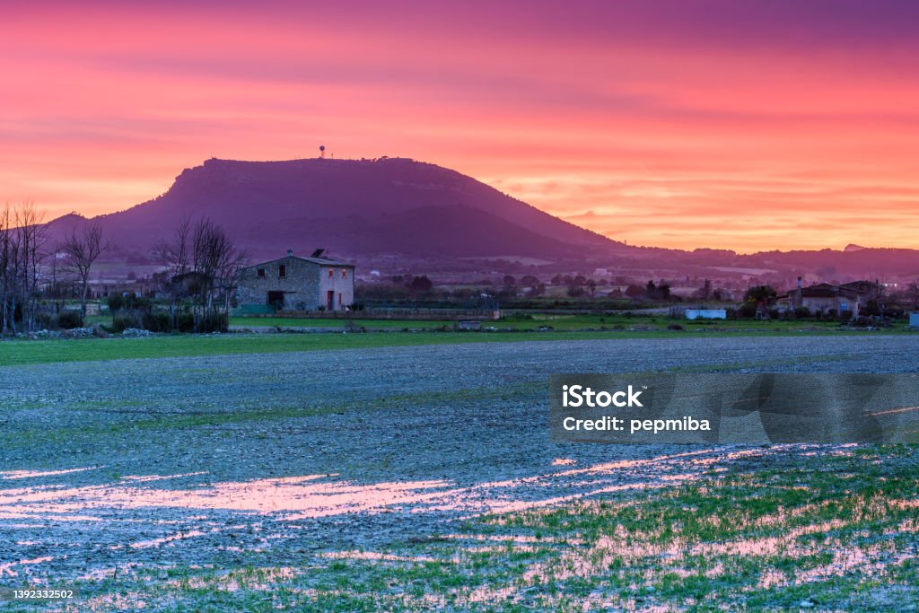 Randa peak at very colored sunset Randa peak at a very colored sunset view from  agricultural fields after torrential rains causing flooding Accidents and Disasters Stock Photo