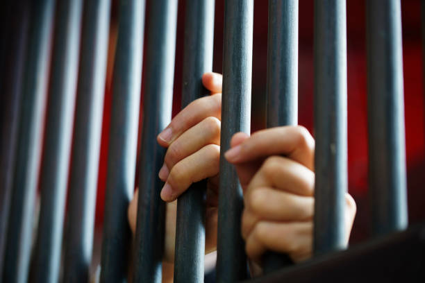 hand in jail close up of women hand in jail with dark background prison stock pictures, royalty-free photos & images