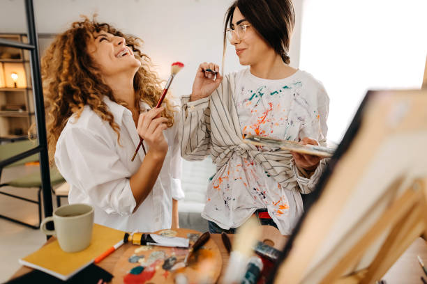 Female fine artists drawing in studio Young artists paint in their studio female friendship painting stock pictures, royalty-free photos & images