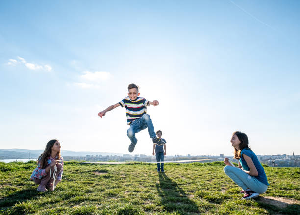 enfants jouant à sauter par-dessus la corde - pre teen boy photos et images de collection