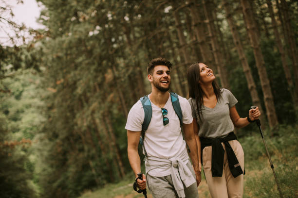 пара туристов с рюкзаками гуляет по лесу - nordic walking hiking mountain walking стоковые фото и изображения