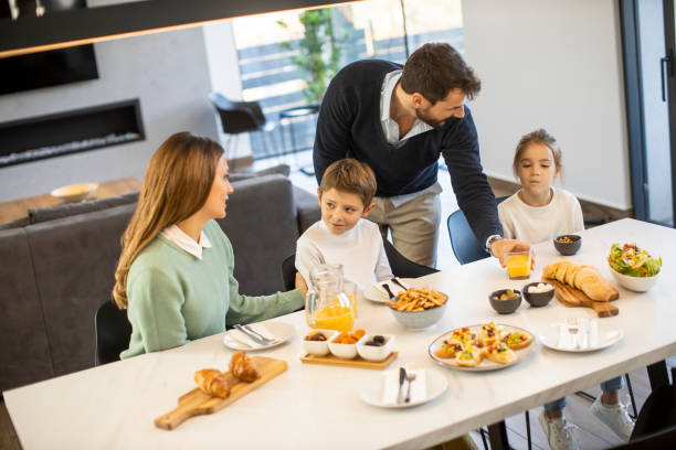 istock Young happy family talking while having breakfast at dining table 1392333956