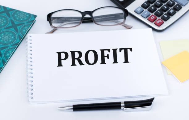 istock PROFIT text on a notebook on the table next to a pen, glasses, tracing paper 1392336595