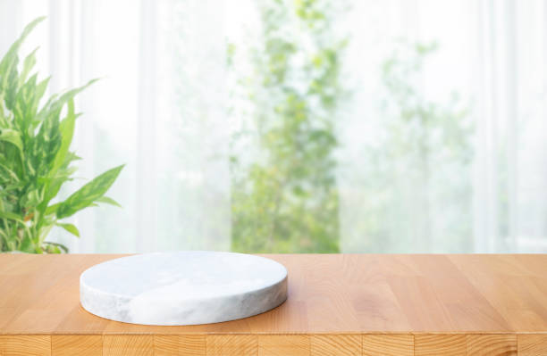 istock Selective focus.Marble display on wood table top and curtain,window background. 1392336697