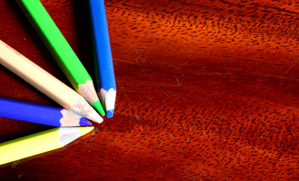 istock colored pencils on brown plank background meeting concept 1392338308