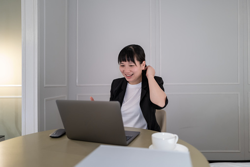 A female white-collar worker showed a happy smile when using a computer for video communication