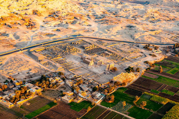 Aerial view The Temple of Ramesseum for Ramses II in Theban Necropolis. Aerial view The Temple of Ramesseum for Ramses II in Theban Necropolis at Valley of The Kings with the village and cultivated land, Luxor, Upper Egypt. medinet habu stock pictures, royalty-free photos & images