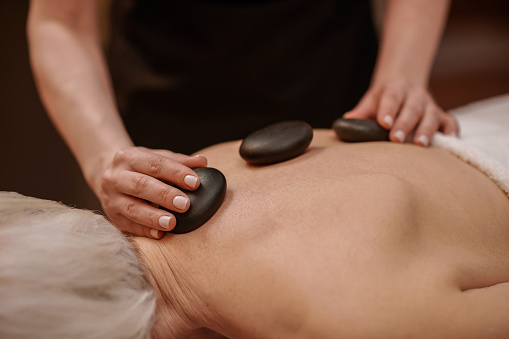 Stone massage .Close up picture of a woman having stone back massage