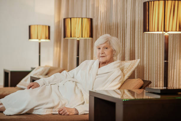 istock A good-looking old lady in a white robe in a hotel room 1392342562