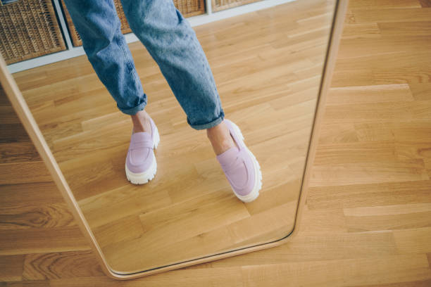 Woman trying new shoes in front of the mirror stock photo