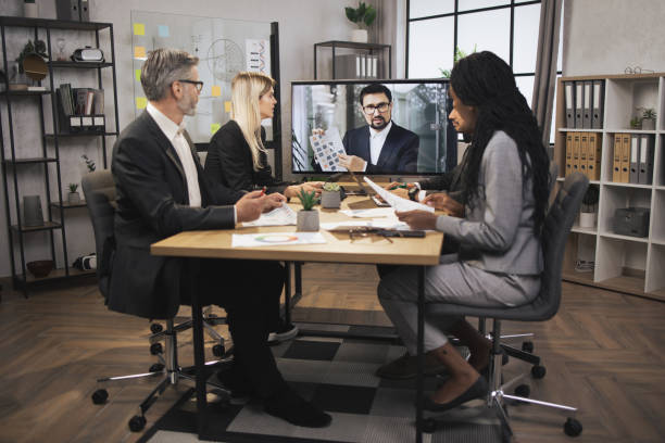 istock Confident bearded Caucasian man tells business program concept to his multinational colleagues 1392343644