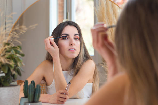 istock Beautiful woman appying eyelash mascara as final touch before going out to lunch 1392345603