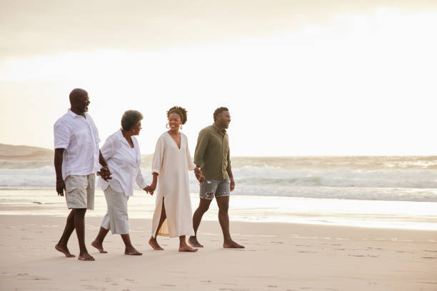 istock Smiling family talking while hand in hand on a beach at sunset 1392345884