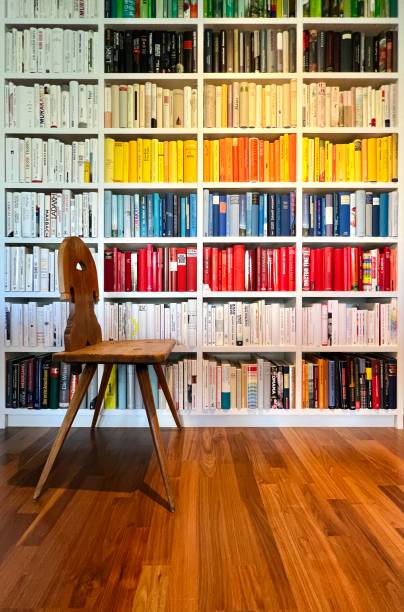istock Library: Book rows in separated colors, wooden chair in front 1392345938