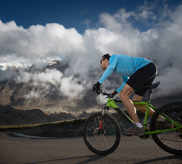istock cyclist riding down in high mountains 1392346954