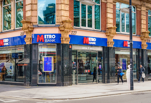 London, UK - Pedestrians passing the entrance to a Metro Bank branch in central London.