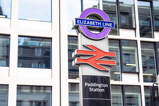London, UK - A sign for the new Elizabeth Line train service, also known as Crossrail, above a red British Rail logo at Paddington Station in London, one of the main interchanges of the service.